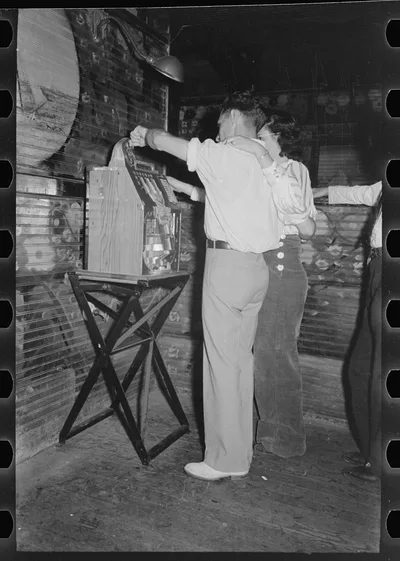 Couple playing slot machine, Raceland, Louisiana, 1938