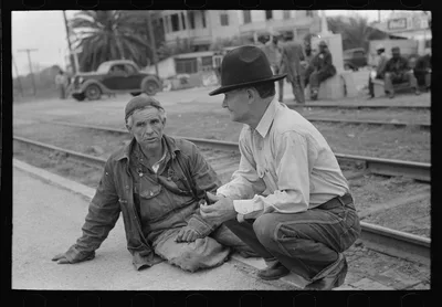 Men squatting on railroad platform, Raymondville, Texas, 1939