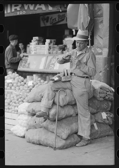 Street vendor rolling cigarette, market square, Waco, Texas, 1939