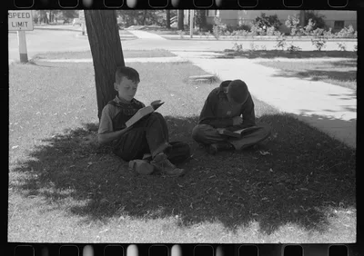 Boys read storybooks in the shade. Caldwell, Idaho, 1941