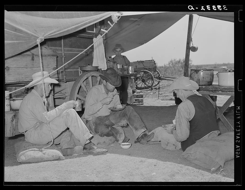 Cowboys of the SMS Ranch eating dinner. Ranch near Spur, Texas, 1939