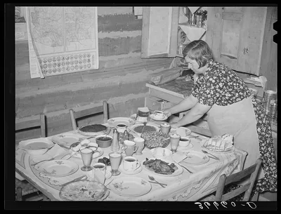 Mrs. Bill Stagg, homesteader's wife, putting the coffee on the table…, New Mexico, 1940