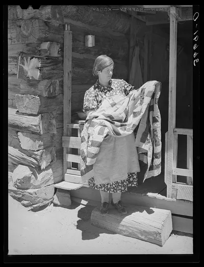 Mrs. Bill Stagg exhibiting a quilt made from tobacco sacks which she…, New Mexico, 1940