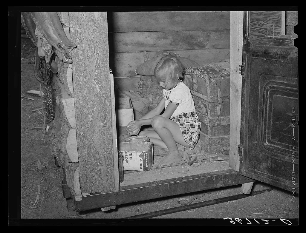 Daughter of homesteader getting chicken feed in slab shed. Trunk seen…, New Mexico, 1940