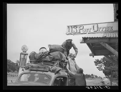 Postmaster at Pie Town, New Mexico, taking a mail sack from the stage, 1940