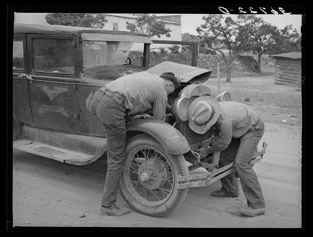 Garage owner and farmer working on a car. Pie Town, New Mexico. The…, 1940
