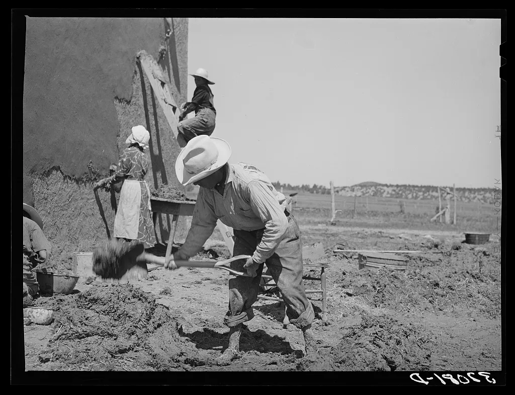 Mixing plaster for house, Chamisal, New Mexico. Occasionally a man…, 1940