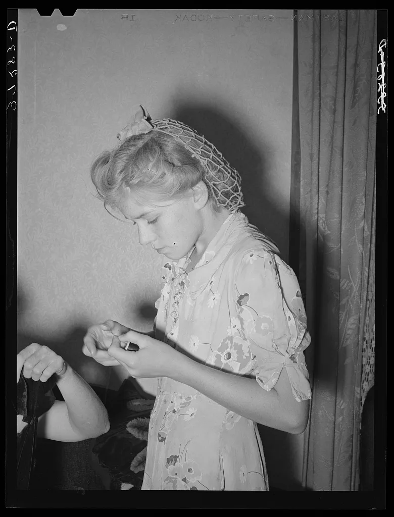 Mormon girl threading a needle. Snowville, Utah, 1940