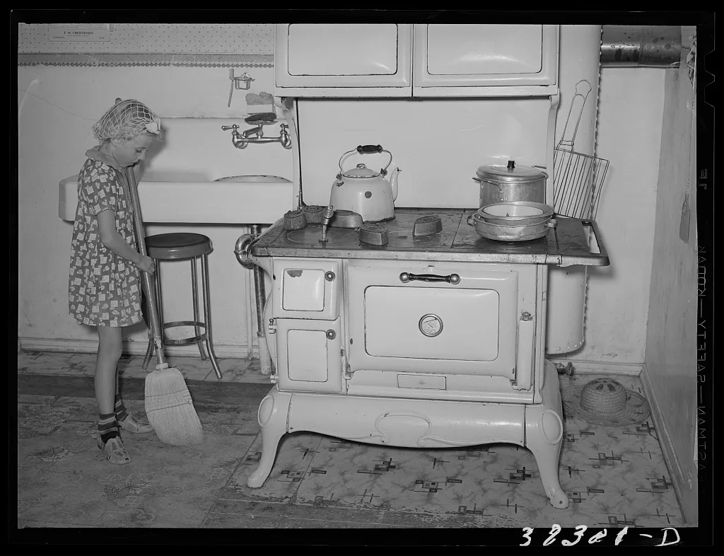 Daughter of Mormon farmer sweeping up the kitchen. Snowville, Utah, 1940