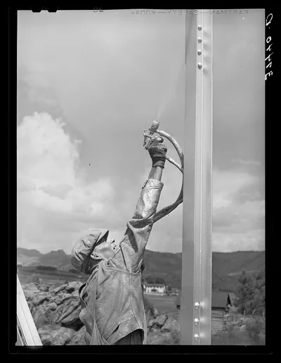 Sapinero, Colorado. Workmen spraying a bridge with silver paint, 1940