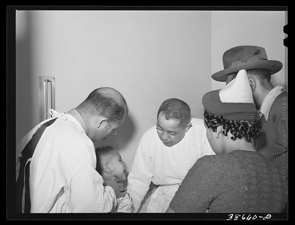 Doctors examining baby whose parents have just brought him into the…, Illinois, 1941