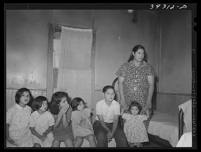 Mexican children with their mother sitting on bed in their home. San…, California, 1941