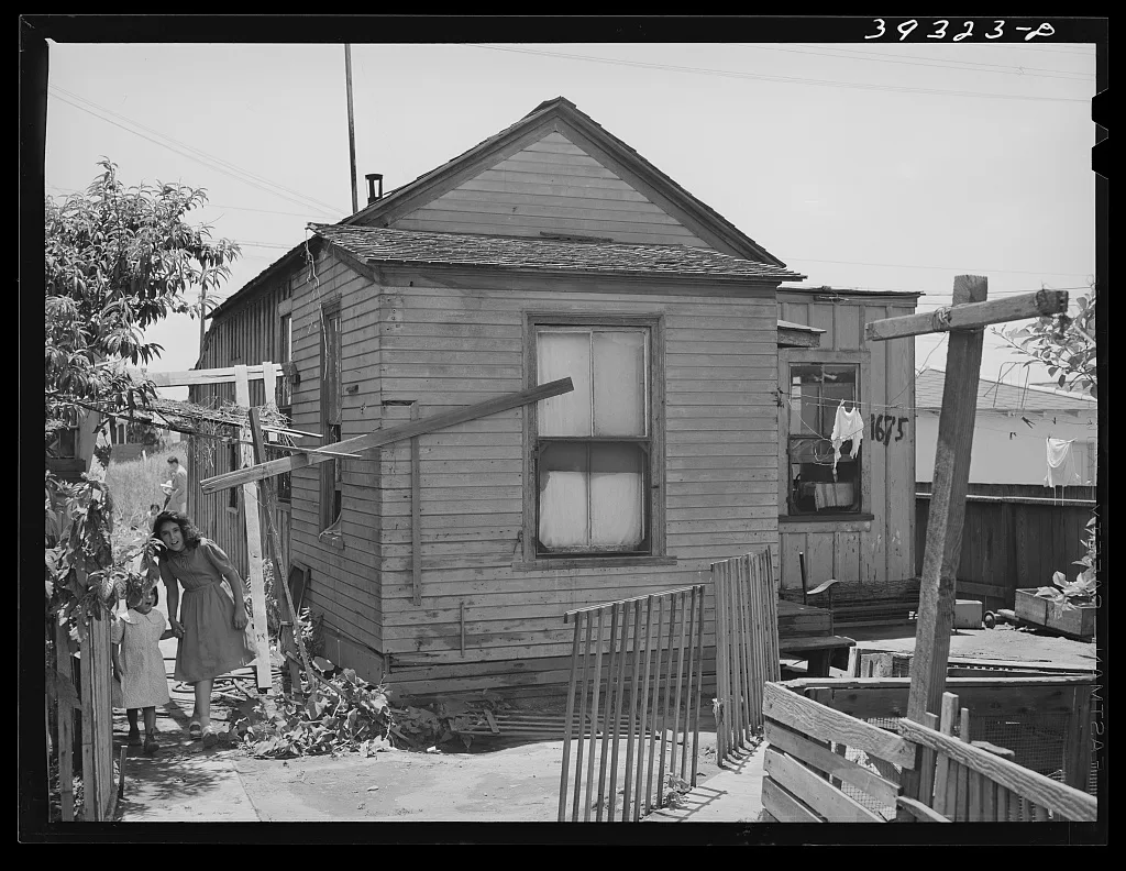 Little Mexican girls coming up alley walk which leads to their home.…, California, 1941