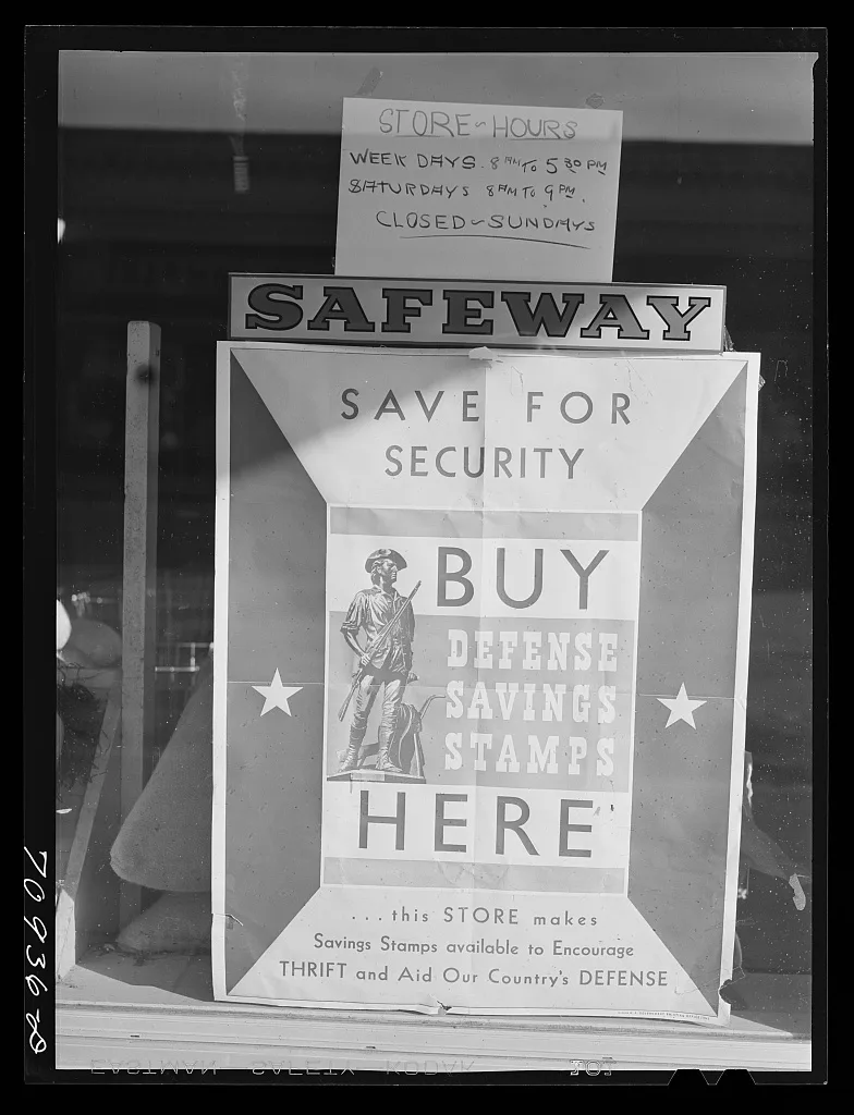 Defense saving stamps sign on grocery store. Payette, Idaho, 1941